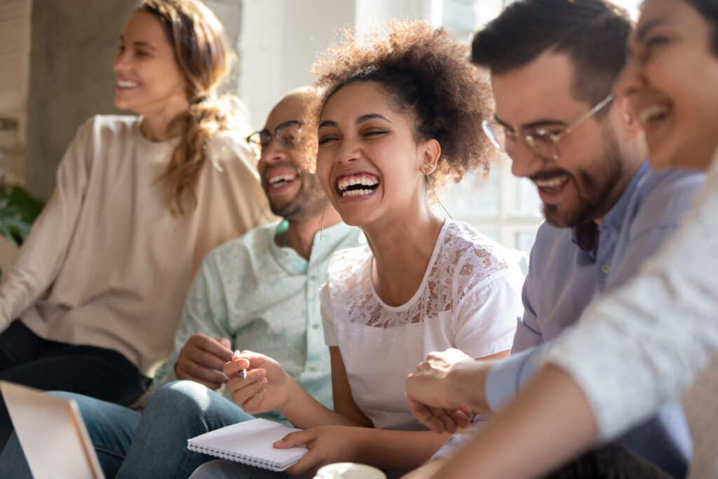 Group of adults laughing together during a supportive group session for BPD treatment.