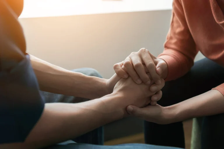 Two people holding hands to support each other through mental health in Philadelphia