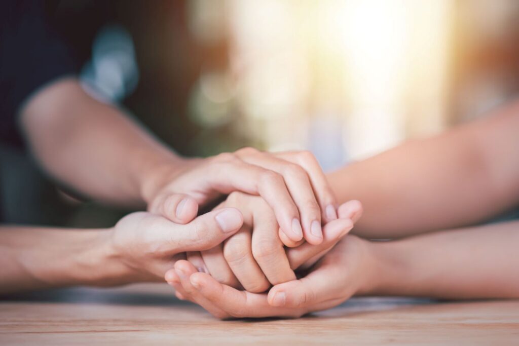 therapist at New Mind Wellness holding the hands of a patients struggling with different types of depression