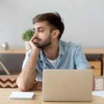 man sitting at his desk at work wondering is it normal to dislike silence when you have adhd