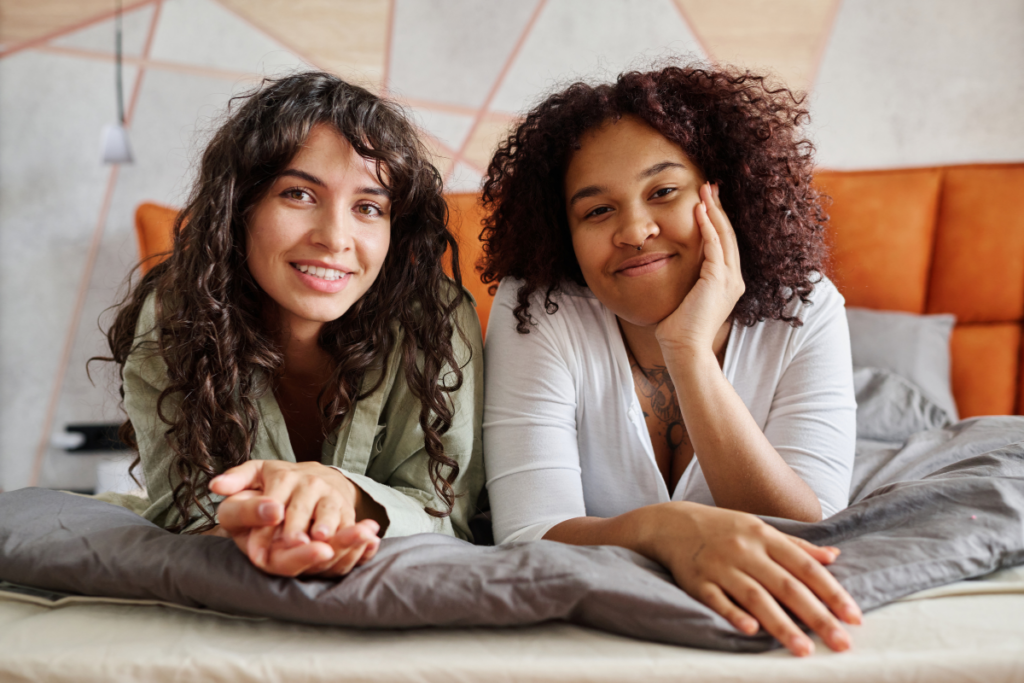 Two women smiling in bed
