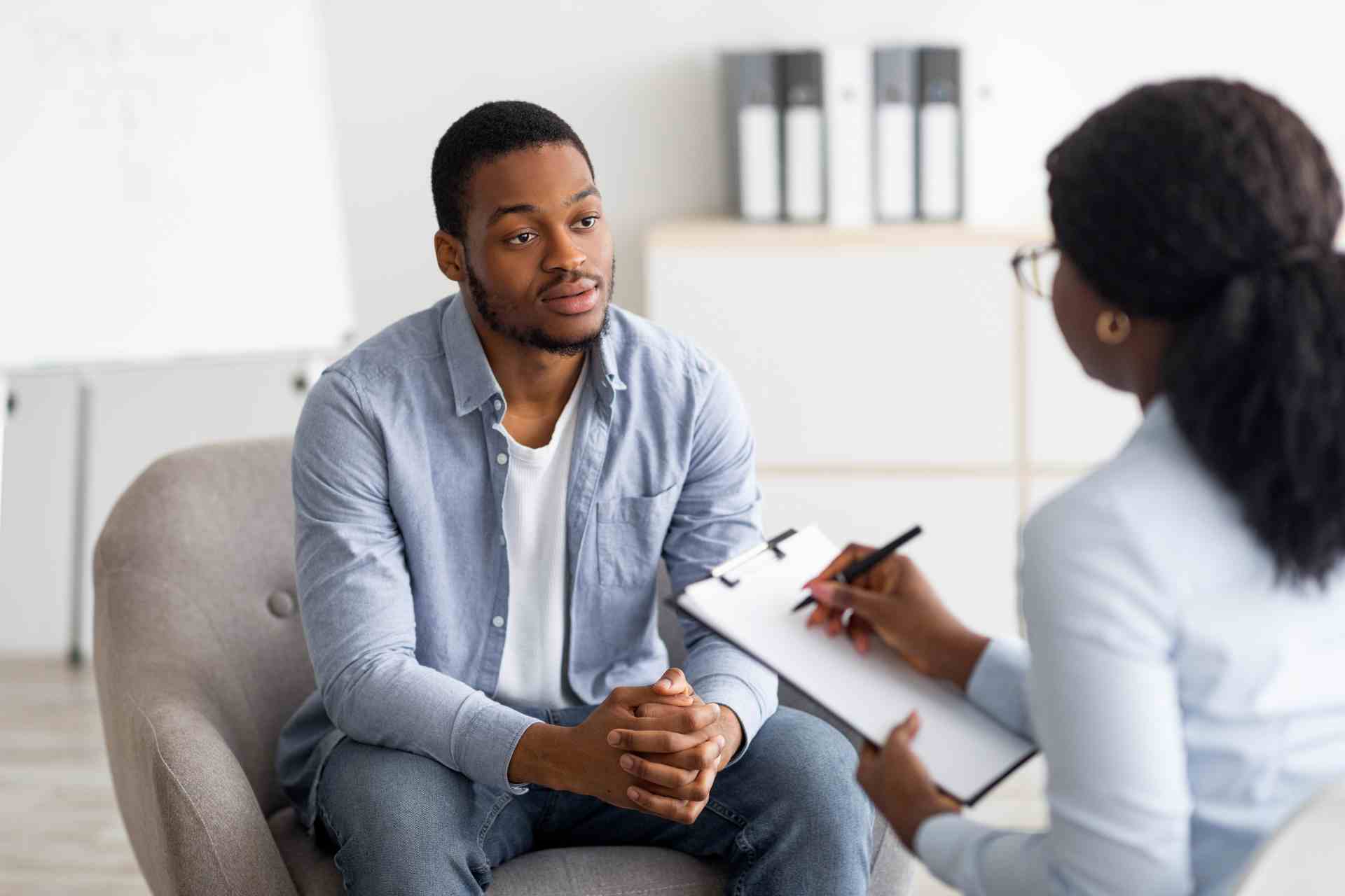 Therapist discussing mental health treatment options with patient during consultation