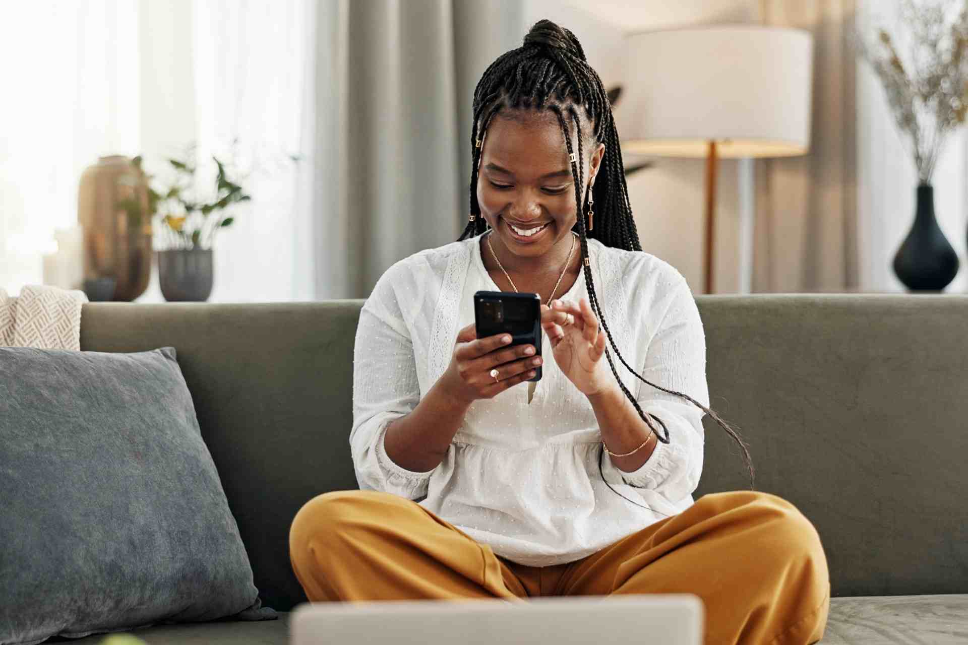 Woman using smartphone at home to check mental health treatment costs and insurance coverage