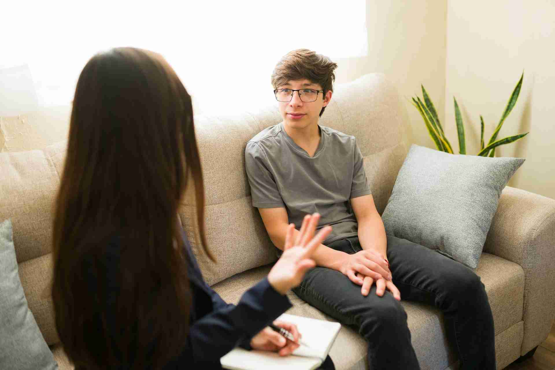 Teenager speaking with a mental health therapist during a counseling session
