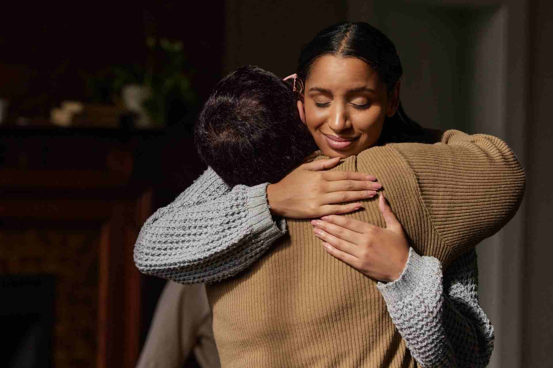 Family member embracing a loved one during mental health recovery, showing compassion, encouragement, and emotional support at home.