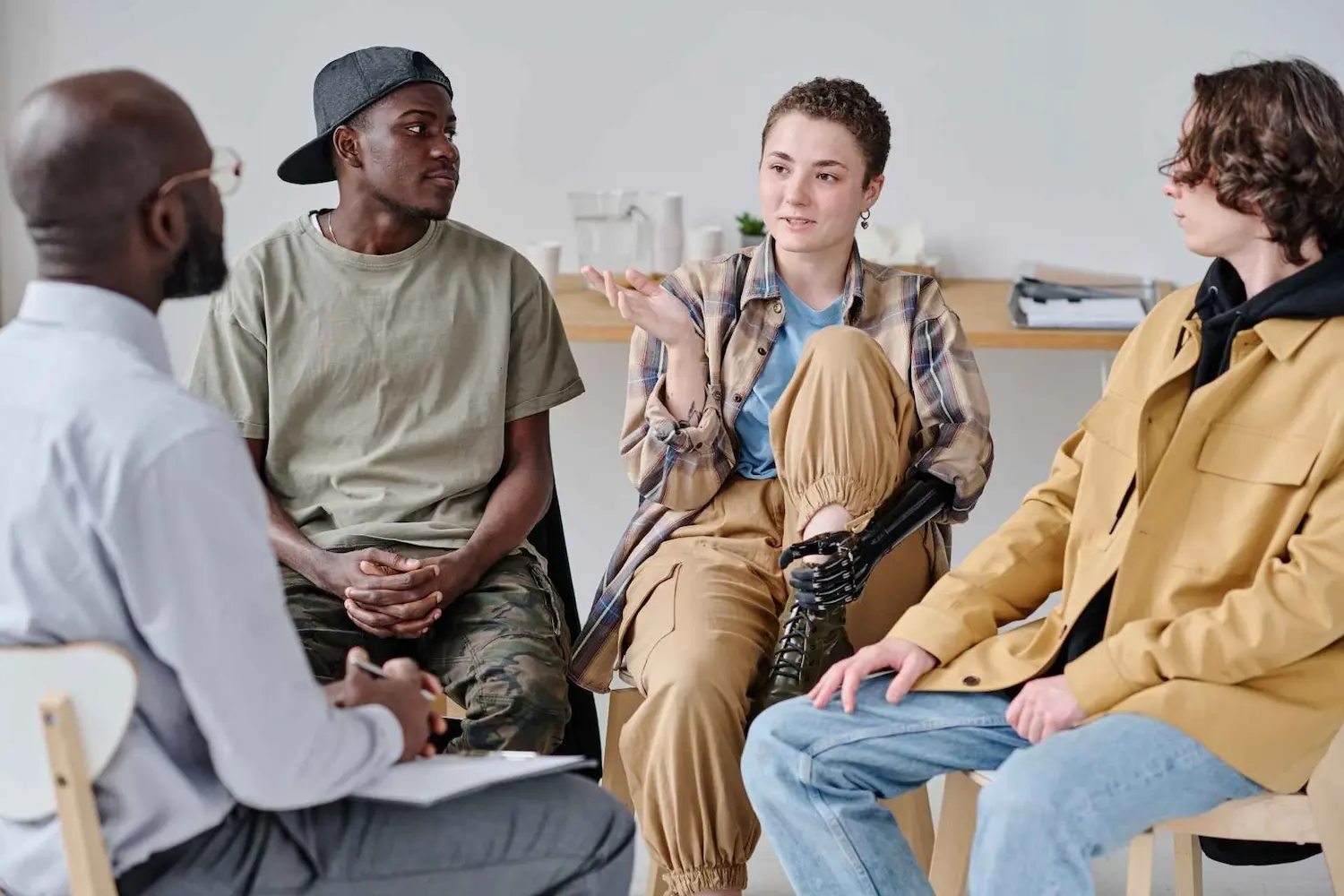Individuals participating in a PHP or IOP group therapy session discussing mental health recovery