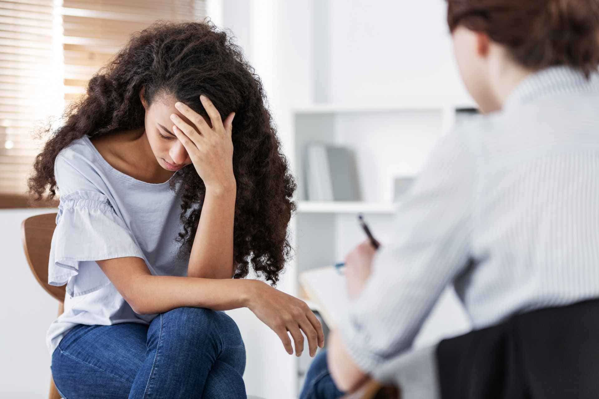 Woman discussing complex PTSD symptoms with a mental health therapist during a counseling session.