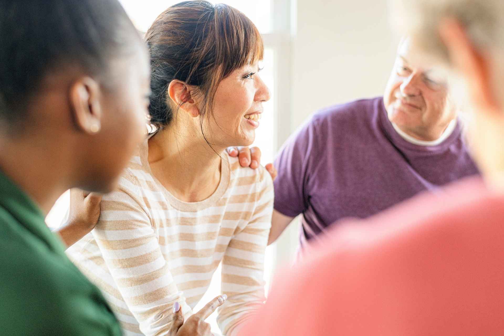 Woman receiving encouragement during a supportive mental health treatment group.